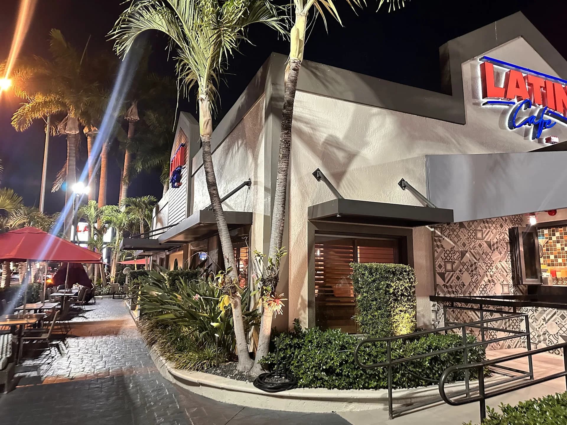 Latin Cafe 2000 exterior with patio, palms and neon sign